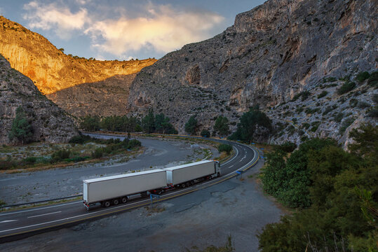 Duo-trailer truck (Long combination vehicle) navigating a serpentine mountain road inside a deep canyon