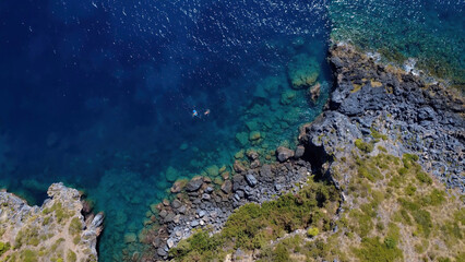 Serene Coastal View With Rocky Shoreline and Clear Blue Waters During Sunny Day
