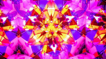 Natural macro kaleidoscope pattern photographed with a camera, showing vibrant abstract geometric shapes in pink, purple, and yellow.