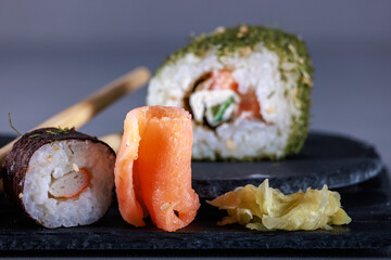 Vielfältige Sushi-Auswahl auf einer dunklen Schieferplatte