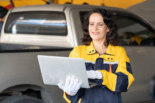 senior mechanic woman working with laptop computer checking or inspection car in auto shop or service garage .