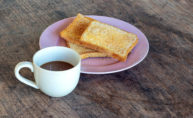 Toasted bread and hot drink on rustic wooden table—simple comfort food for a cozy morning or casual snack.