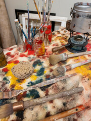 arrangement of artists brushes and other equipment on work table