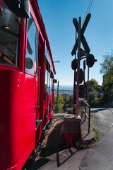 Red train Ferrovia a cremagliera Granarolo in Genoa with a blue sky
