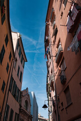 narrow Italian alley in Genoa with blue sky