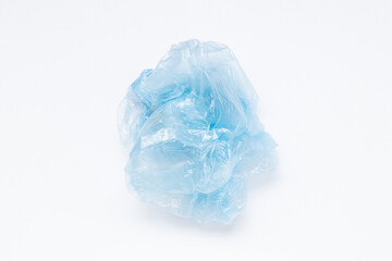 Obraz premium Close-up of a blue crumpled plastic bag lying on a white