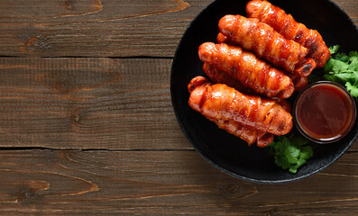 Bacon wrapped sausages with barbecue sauce