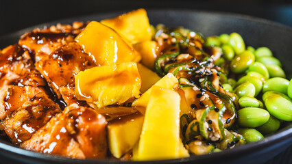 Beautiful poke bowl with grilled salmon, fresh mango, edamame, and glossy sweet-teriyaki sauce. A delicious and healthy fusion of Hawaiian and Japanese flavors.