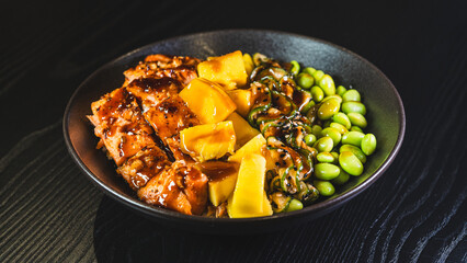 Beautiful poke bowl with grilled salmon, fresh mango, edamame, and glossy sweet-teriyaki sauce. A delicious and healthy fusion of Hawaiian and Japanese flavors.