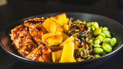 Beautiful poke bowl with grilled salmon, fresh mango, edamame, and glossy sweet-teriyaki sauce. A delicious and healthy fusion of Hawaiian and Japanese flavors.
