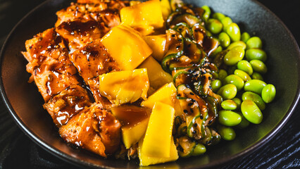 Beautiful poke bowl with grilled salmon, fresh mango, edamame, and glossy sweet-teriyaki sauce. A delicious and healthy fusion of Hawaiian and Japanese flavors.