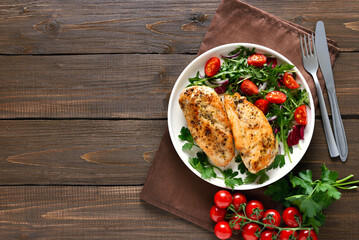 Baked chicken breast and vegetable salad on plate