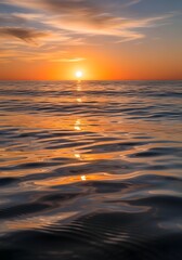Golden hour reflecting on the ocean water and the horizon at sunset in the evening sky