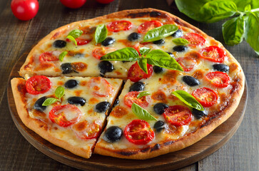Homemade pizza with tomato and olives