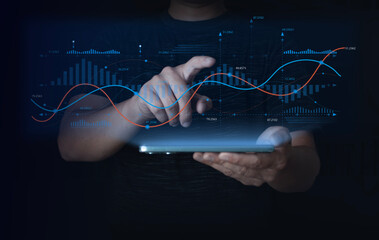  Businessman using tablet to analyze digital financial data with glowing line and bar graphs. Concept of big data analytics, fintech, technology, and futuristic business performance visualization.