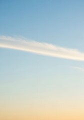 A beautiful gradient sky with a single cloud stretching across the horizon at sunrise or sunset