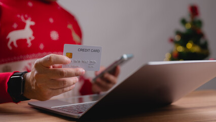 Festive Person Using Credit Card for Online Shopping on Laptop