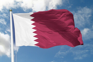  national flag of Qatar waving in the wind against a clear blue sky, symbolizing national pride, unity, and the country’s heritage, culture, and progress across the Arabian Gulf.