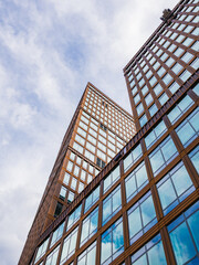 Modern office building facade in Gothenburg showcasing a blend of glass and wood under a cloudy sky