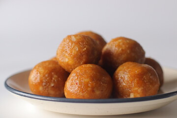 Jackfruit laddus on a white backdrop, made with pureed jackfruit, raw sugar and coconut