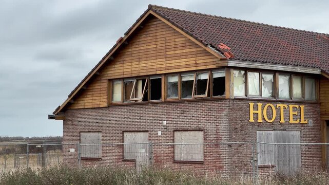Abandoned hotel facade detail with broken windows