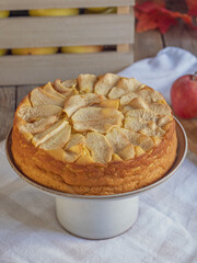 Homemade apple cake with fresh apples and wooden box on rustic table