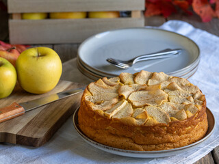 Homemade apple cake with fresh apples and wooden box on rustic table