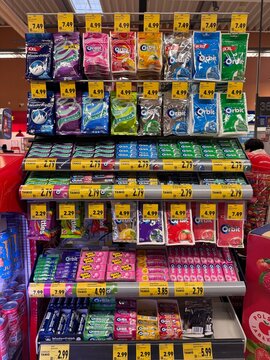 A supermarket display case with chewing gum from popular brands such as Orbit, Dirol, Eclipse, and Wrigley. Bright packaging, price tags, and an everyday retail scene.