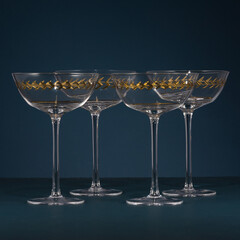Set of crystal cocktail glasses with gold geometric detailing on dark background, perfect for luxury tableware, fine dining, elegant entertaining, interior styling, and product photography