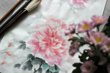Peony in the style of traditional Chinese painting Sumi-e, Wu-xing, guo-hua. An image on rice paper with flowers and brushes. Training in oriental painting.