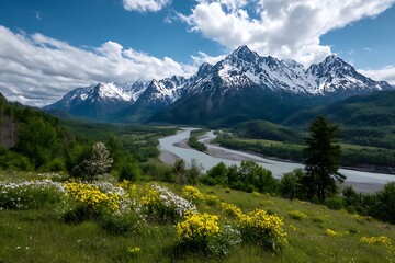 A sprawling green landscape with a large river winding through flower fields, set against a backdrop of towering snowy mountain peaks beneath a vibrant blue sky with fluffy clouds.