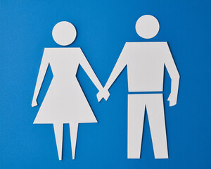 Paper cutouts of a loving couple holding hands on a bright blue background symbolizing togetherness and commitment