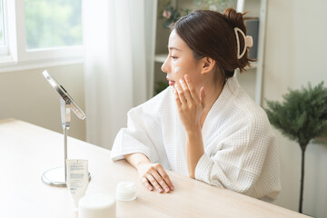 Facial beauty skin care, smile of pretty asian young woman in bathrobe looking at mirror, hand...