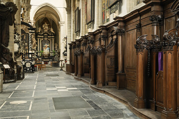 Obraz premium Wooden confessional with carved columns and a purple curtain symbolizing penance, set against ornate wooden paneling. St. Andrew's Church in Antwerp