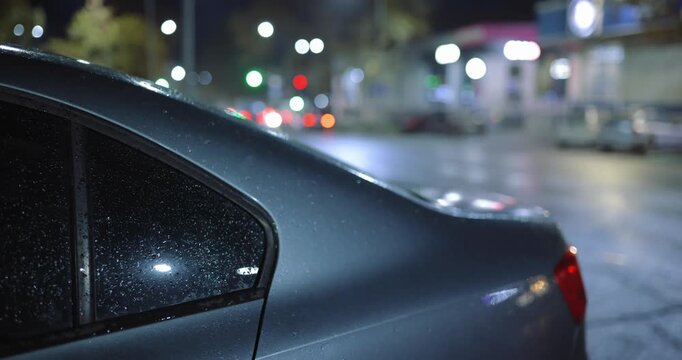 Rainy car at night with blurred city background, contains original audio