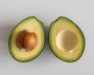 Freshly cut avocado halves with seed, perfect for food blogs, healthy eating, and culinary projects