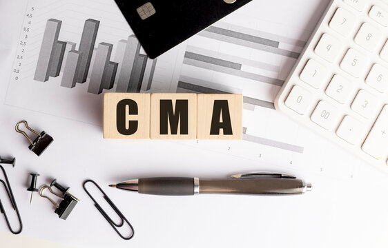 CMA word on wooden blocks with charts, credit card, calculator and office supplies on white desk