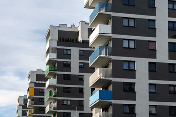 Contemporary apartment buildings with colorful balconies in blue, green, and yellow tones,...