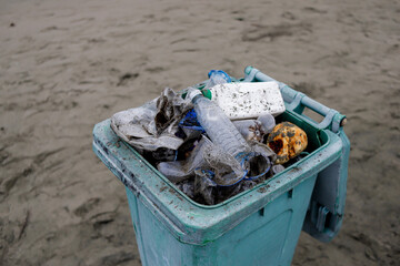 Overflowing Trash Bin on Beach – Plastic Pollution and Environmental Awareness Concept