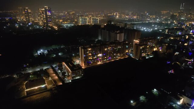 aerial drone panning shot showing buildings and skyscrapers brightly decorated with colourful lights on the Indian festival of diwali showing the celebrations and festivities