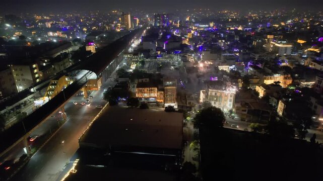 Aerial drone orbit shot over small houses and busy road with fireworks on the horizon showing the celebration of the indian festival of Diwali the festival of lights and bringer of wealth