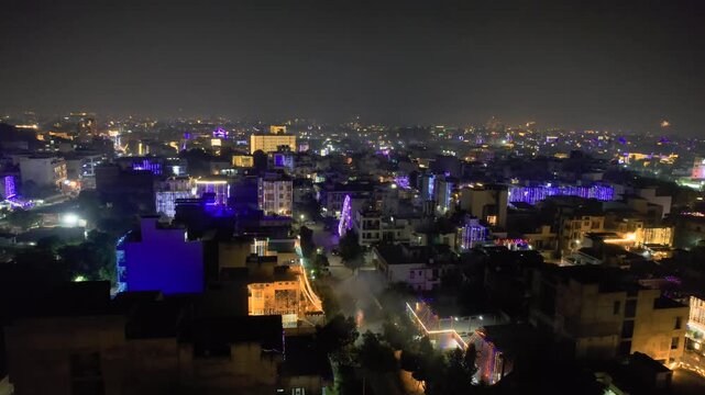 aerial drone shot low over houses decorated with bright colorful lights with fireworks in the sky above near the drone showing the celebrations on the indian festival of diwali in jaipur, delhi, noida