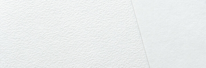 Close-up texture of two types of white paper with different finishes and subtle patterns.