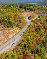 Aerial photography of highway and forest with vibrant colorful autumn foliage near / around Acadia...