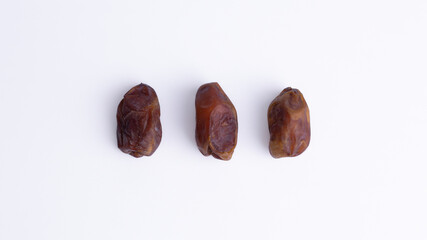 Flat lay of Three Sukkari Dates on White background. Delicious, high-energy fruit, perfect for Iftar, healthy snacks, or baking.
