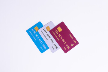Three Tilted Fictional Cards Blue, White, Red on White. Variety of banking products, secure online payment, and contactless service.
