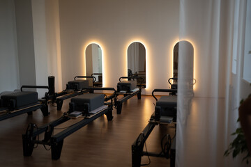 Serene pilates space, peaceful pilates environment featuring soft lighting and organized reformers