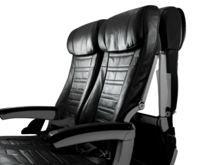 Close-up of two black leather airplane seats on a black background, showing plush design and comfort