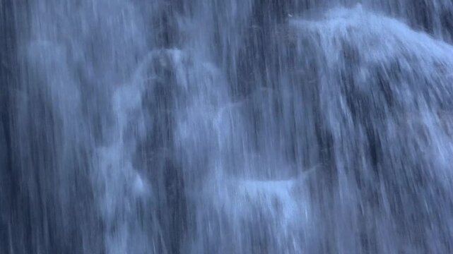 Mystischer Wasserfall eines Wildbaches an einer Bergwand, Alpen