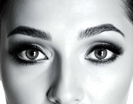 Close-up of woman's face focusing on eyes with expressive eyebrows, grayscale
